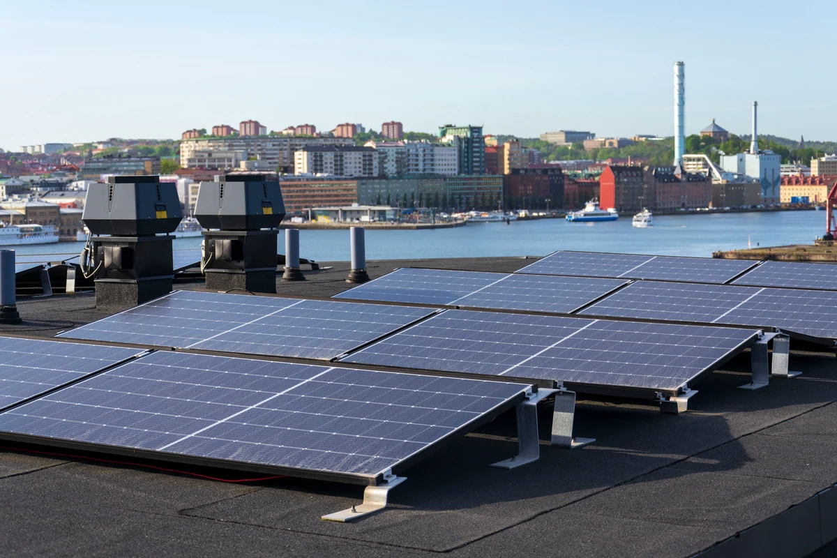 Solpaneler på tak av flerbostadshus med Göteborgs centrum i bakgrunden